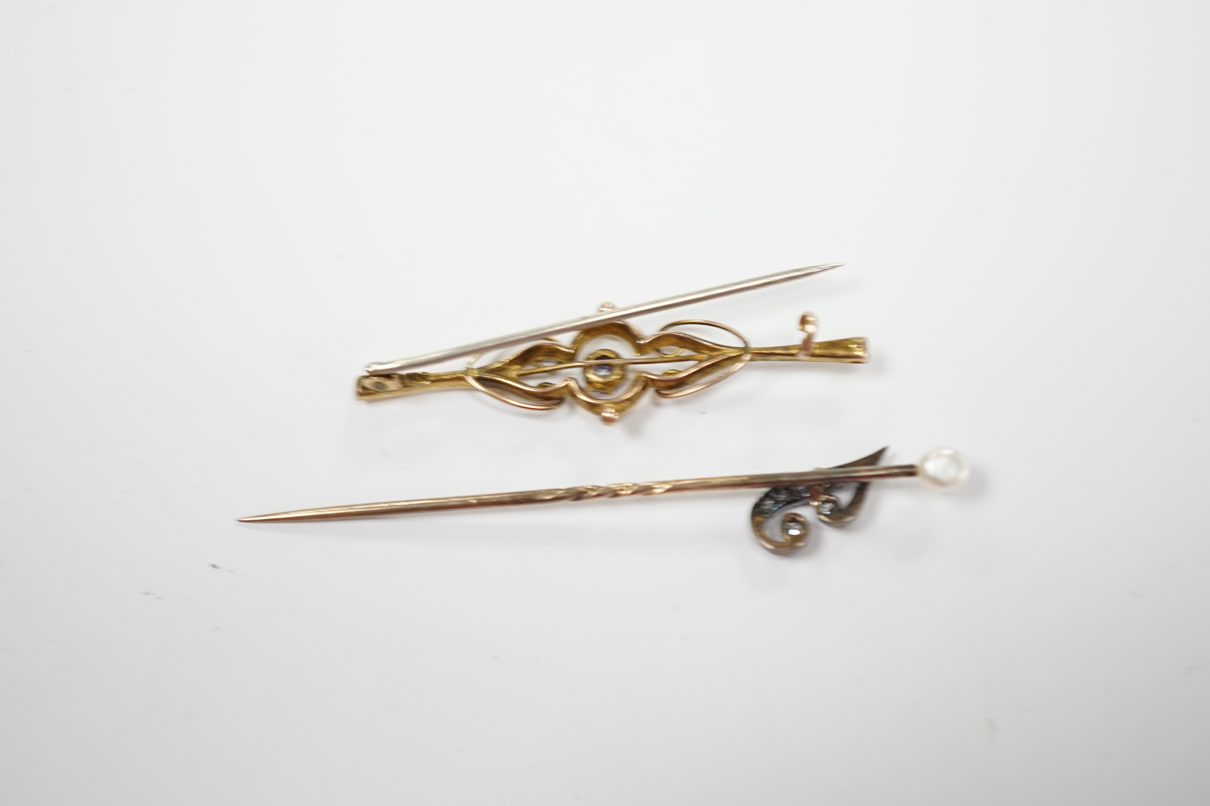 An early 20th century diamond chip and seed pearl set initial stick pin, 65mm and a 9ct and gem set brooch.